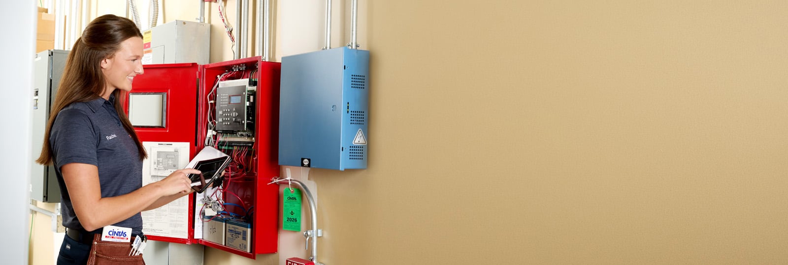 cintas fire protection services representative inspecting alarm panel