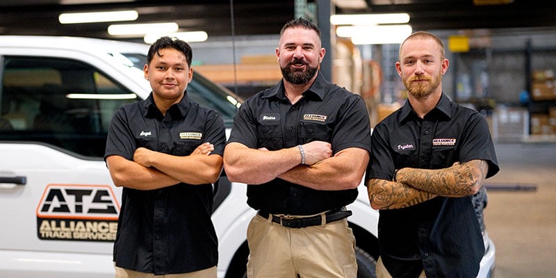 Three alliance workers in front of a truck